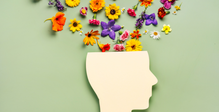 A cut out image of the mind with flowers coming out of it to represent mindfulness and mental health.