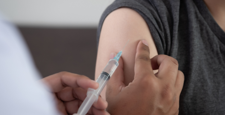 Picture of a doctor administering a vaccine to a patient.