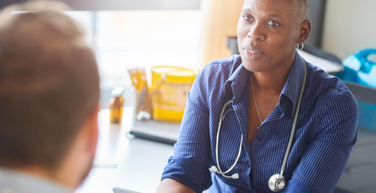 A doctor listening to a patient during their appointment.