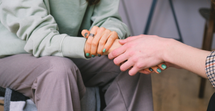 A young person being comforted by another person.