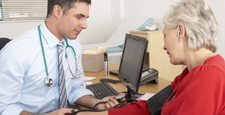 Doctor Taking Senior Woman's Blood Pressure.