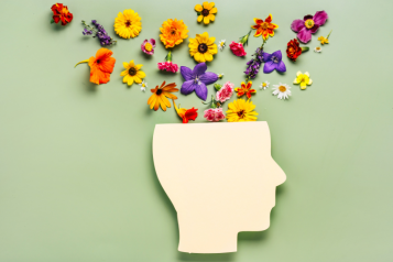 A cut out image of the mind with flowers coming out of it to represent mindfulness and mental health.