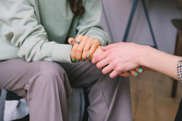 A young person being comforted by another person.