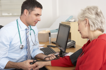 Doctor Taking Senior Woman's Blood Pressure.